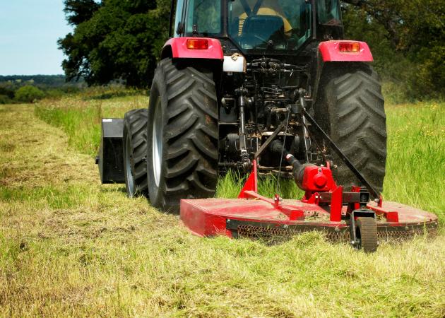 small tractor cutting high grass
